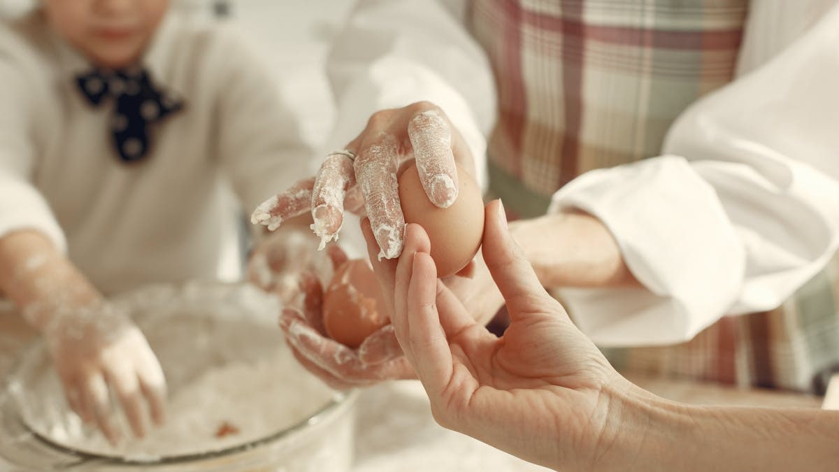 A close-up of hands preparing dough, emphasizing family teamwork.